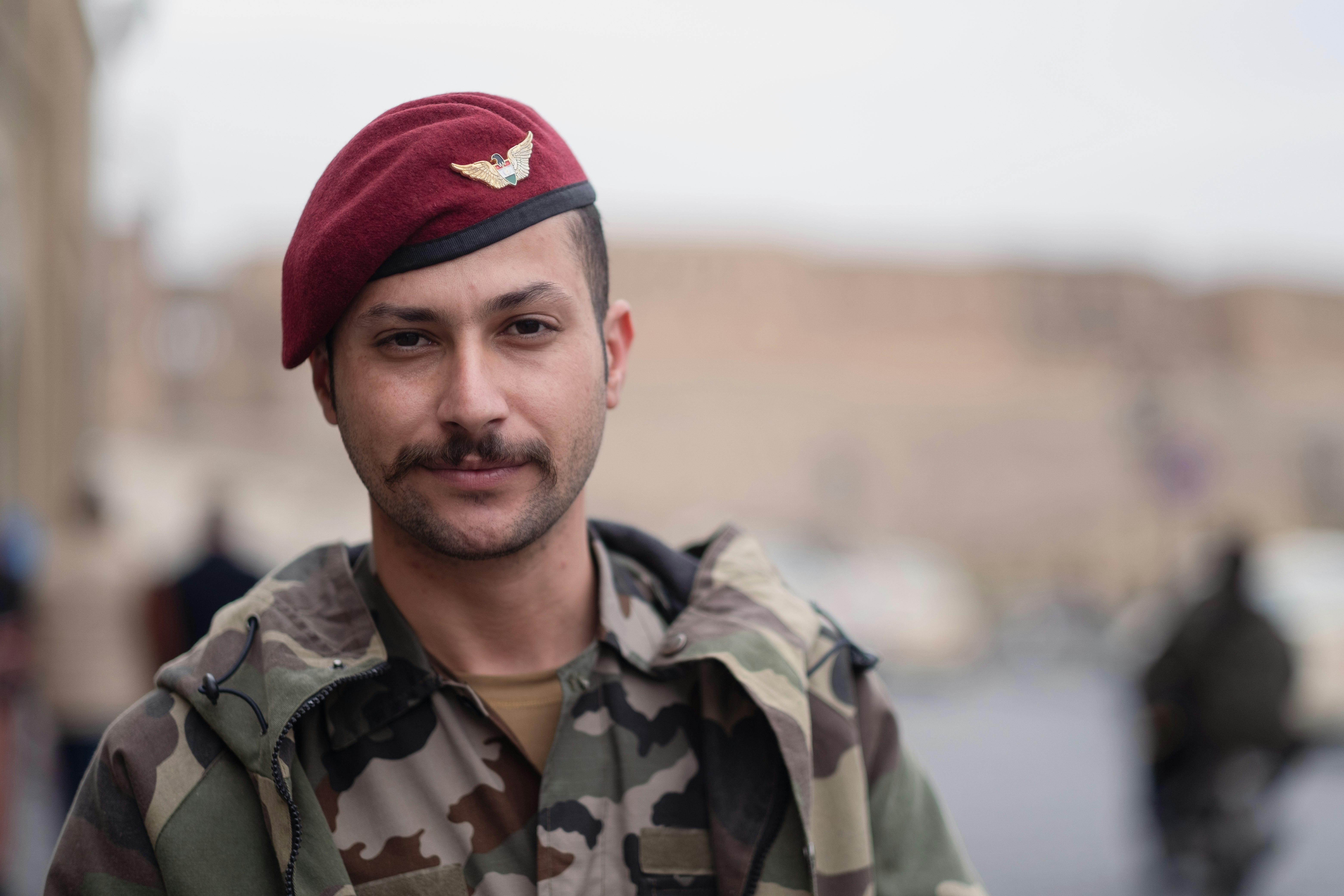 man in green camouflage jacket and red knit cap